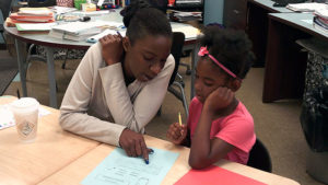 a third grade student and her family member work on creating their story together.