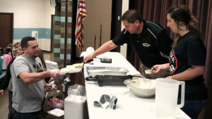 Mr. Chiaro serves pancakes to a teacher to pass out to the students.