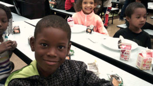 a Jefferson student smiles for the camera after he has finished his pancake breakfast.