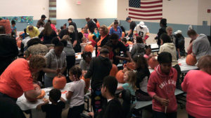 An overview of Jefferson Cafeteria as students and helpers work on their pumpkins.