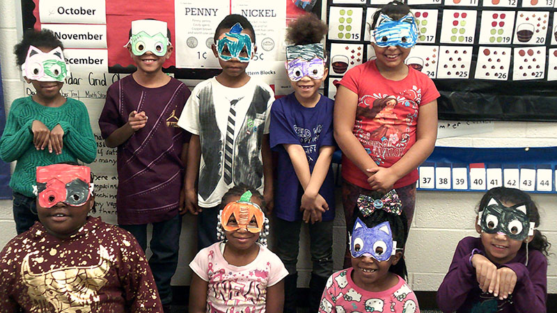 Students in 1st grade show off their masks created during their family day celebration.