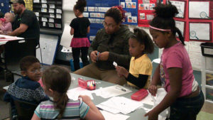 1st grade students and guests working on their family day crafts.