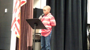 A student recites a poem for the program.