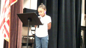 A student recites a poem for the program.