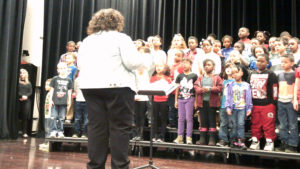 Ms. Turner leads second grade students for a song during the program.