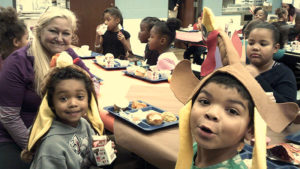 Second grade students enjoying their Thanksgiving lunch.