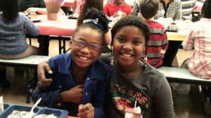 Two Jefferson students take a break from their Thanksgiving lunch to smile for the camera.