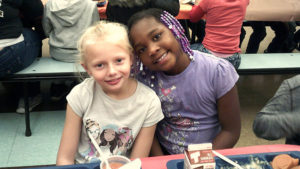Two Jefferson students take a break from their meal to smile for the camera.