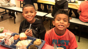 Two first grade students ready to enjoy their lunch.