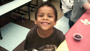 A Kindergarten student smiles for the camera.