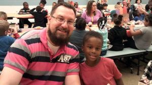 Mr. Bitner and a first grade student enjoying the Thanksgiving lunch.