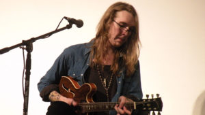 Dennis plays his guitar for staff and students.