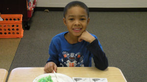A first grade student enjoying his green eggs and ham.