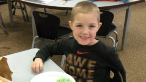 A kindergarten student enjoying his green eggs and ham.