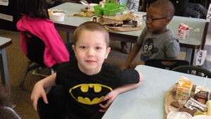 a kindergarten student waits patiently for his green eggs and ham.