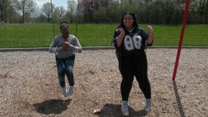 A Harding student and a third grader enjoy swinging on the swings.