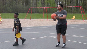 A Harding student and a third grader enjoy some time on the basketball court.