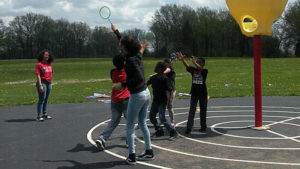 A Harding student uses the bubble wand as others try to catch the bubbles.