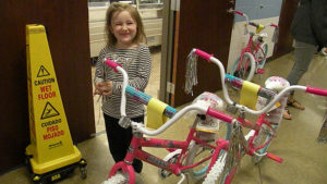 A kindergarten student shows her excitement about winning her new bike.