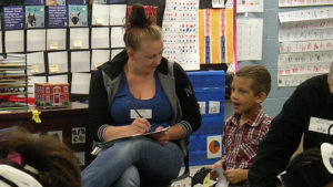 A kindergarten student talks about his poetry activity with his guest.