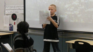 A student reads a poem that he created.