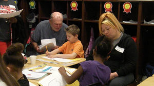 Students work on their poetry activity with their guests.