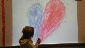 A second grade student reads part of a poem that he worked on with other classmates.