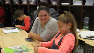 A student and her guest having fun while working together on their math activity.