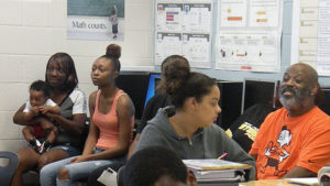 Families watch on as the students complete their classroom work.