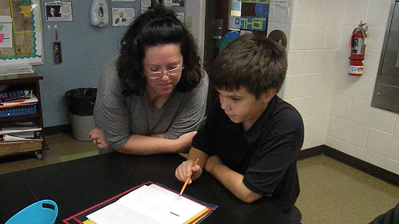 A mother and her son work on an assignment.
