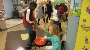 Kindergarten students pass out candy.