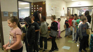 Mr. Bitner greets students as they walk past his classroom for the candy walk.