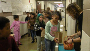 Mrs. Goodyear passes out candy to students as they pass her office.