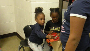 Students pass out candy outside of their classroom.