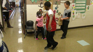 Students collect candy as they walk past a kindergarten class.