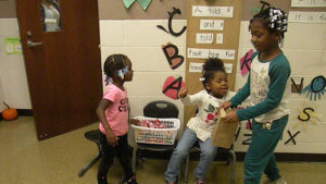 Helpers pass out candy in front of their classroom.