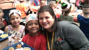 Mrs. Rhodes smiles with one of her students.