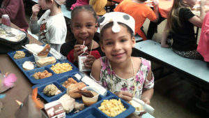 Kindergarten students smile for the camera.