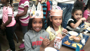 Students take a break from their lunch to smile for the camera.