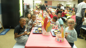 A classroom enjoys lunch together.