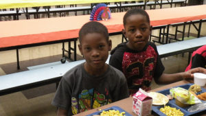 Third grade boys enjoying their Thanksgiving meal.
