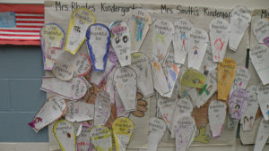 Kindergarten students write what they are thankful for.