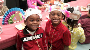 Kindergarten friends take a break from the lunch to smile for the camera.