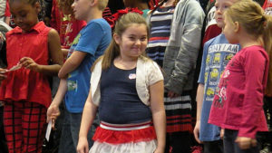 A third grade student smiles for the camera before the concert begins.