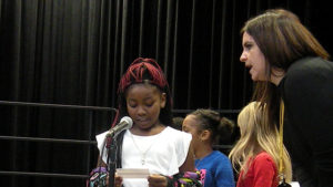 A student practices her poem for the concert.