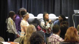 A student introduces herself to the conference audience and explains their purpose for being there.