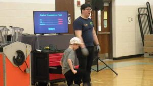 A COSI worker explains what the kindergarten student will do as a volunteer.