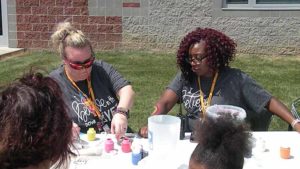 Ms. Marshall gets a rainbow painted on her arm by Ms. G.