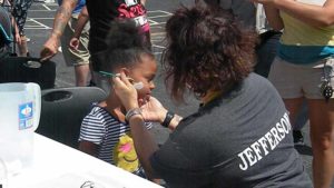 A student gets her face painted.