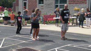 Teachers and students dancing to the cupid shuffle.